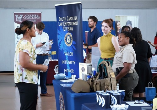 image of smiling on campus employer.  dark hair. 